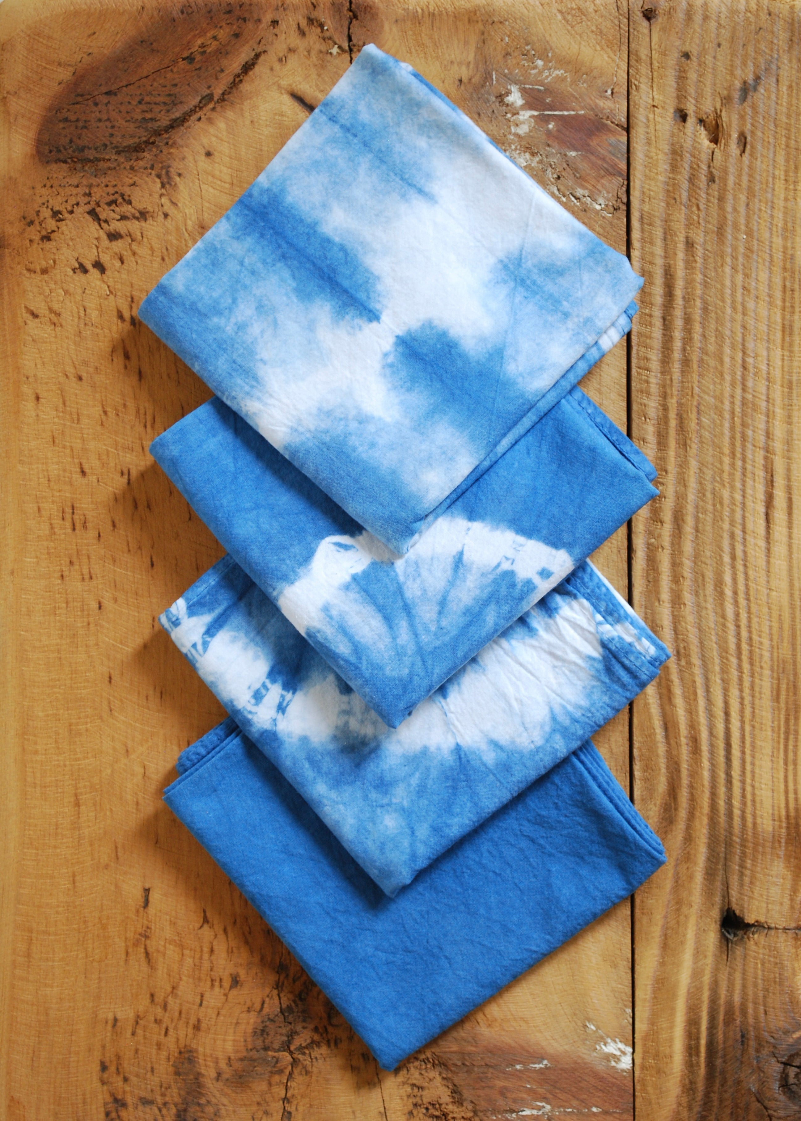 Natural indigo hand dyed organic cotton bandanas in solid and shibori patterns