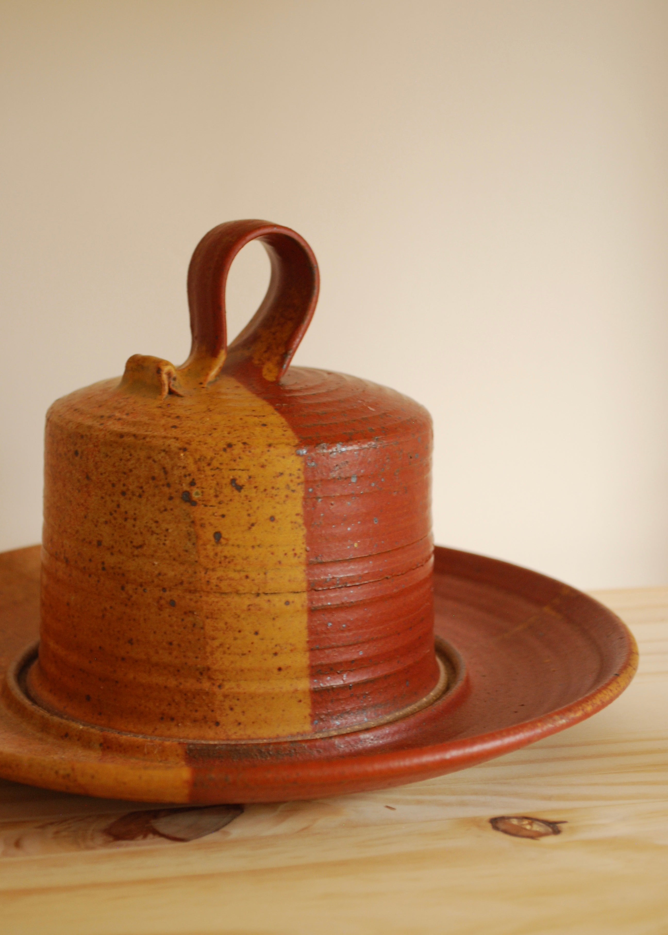 Hand spun ceramic cheese or dessert platter in orange and red glaze and natural clay.