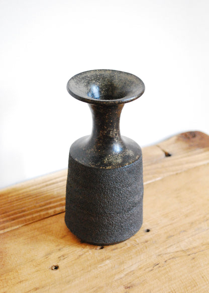 Handmade ceramic vase in textural black clay with a tenmoku glaze and spout at top 