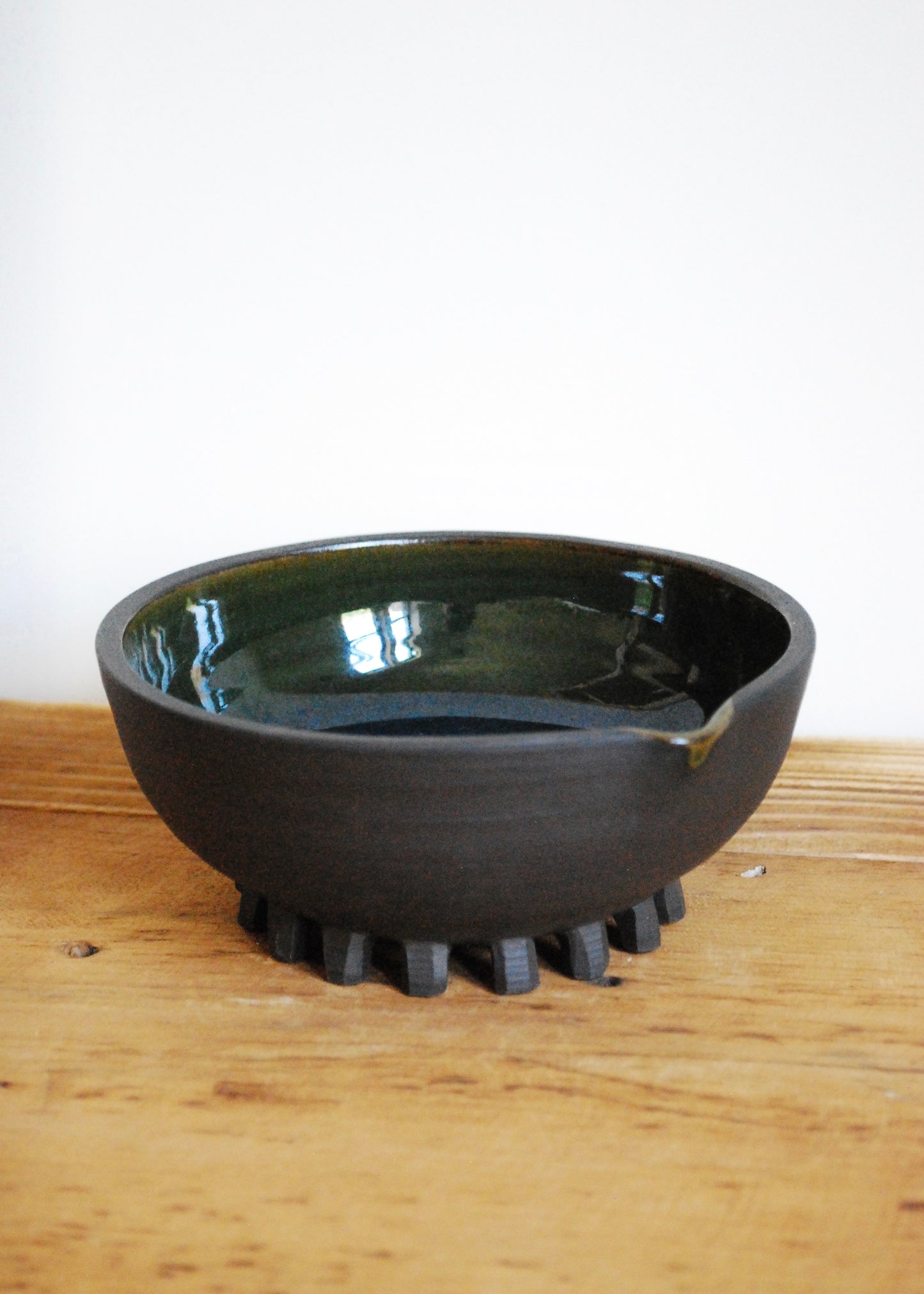 Handmade ceramic matcha bowl made in a black clay with blue and green interior glaze  