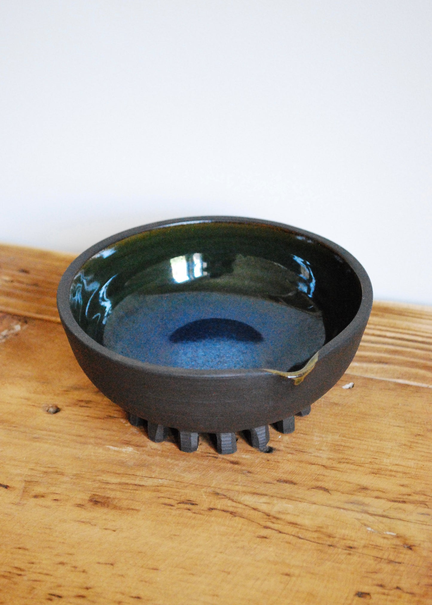 Handmade ceramic matcha bowl made in a black clay with blue and green interior glaze  