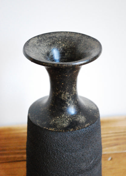 Handmade ceramic vase in textural black clay with a tenmoku glaze and spout at top 