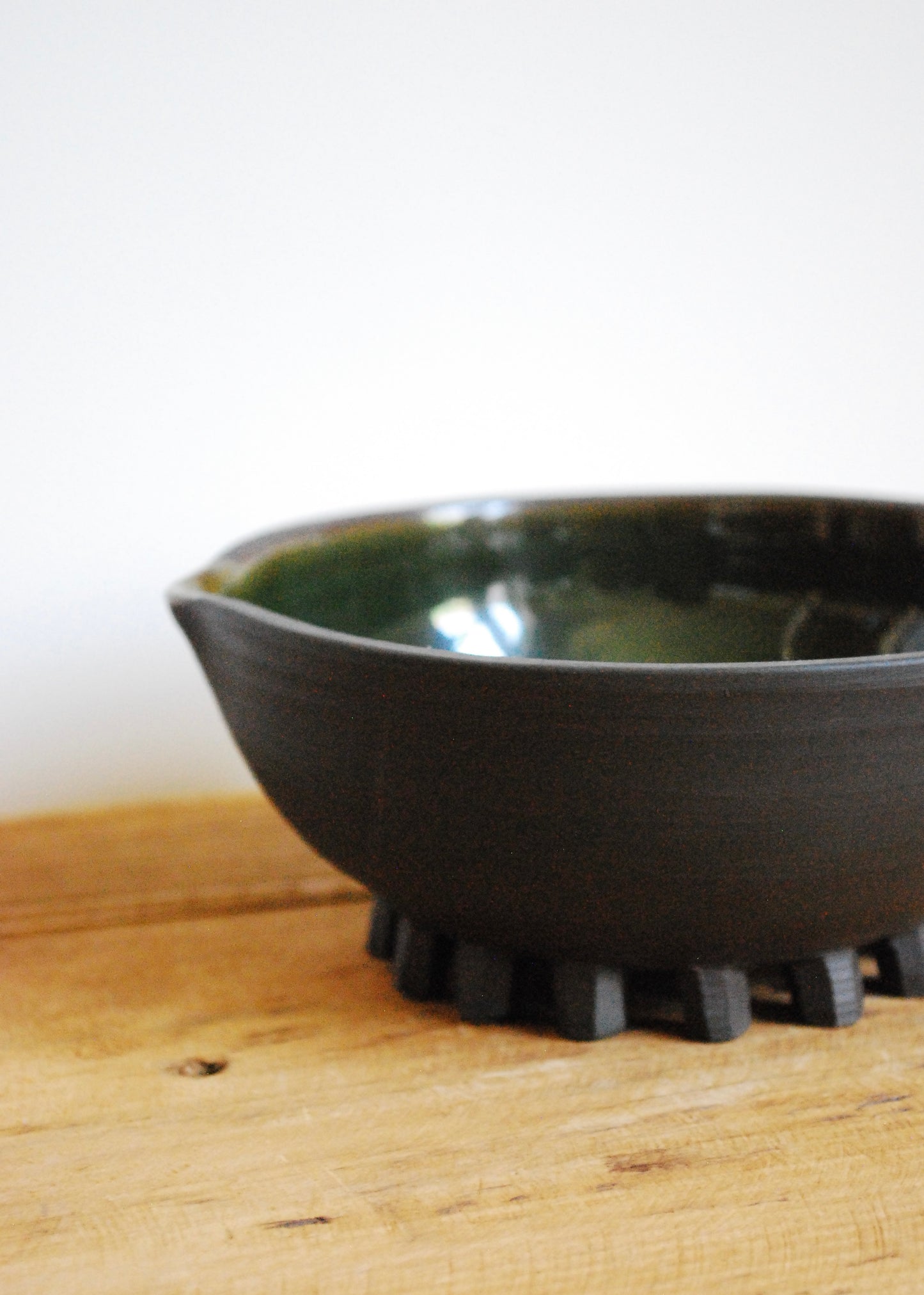 Handmade ceramic matcha bowl made in a black clay with blue and green interior glaze  